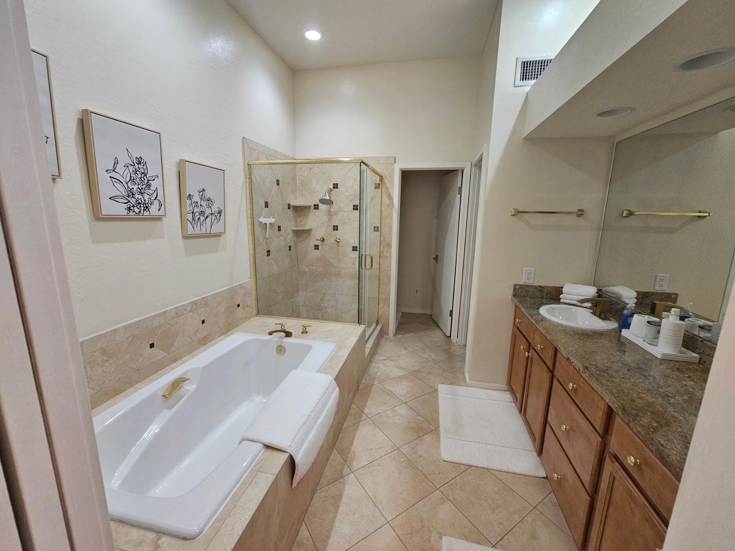 7700 East Gainey Ranch Road, Unit 153 Scottsdale, AZ 85258 - Photo 19 of 24 a spacious bathroom with a tub sink and mirror