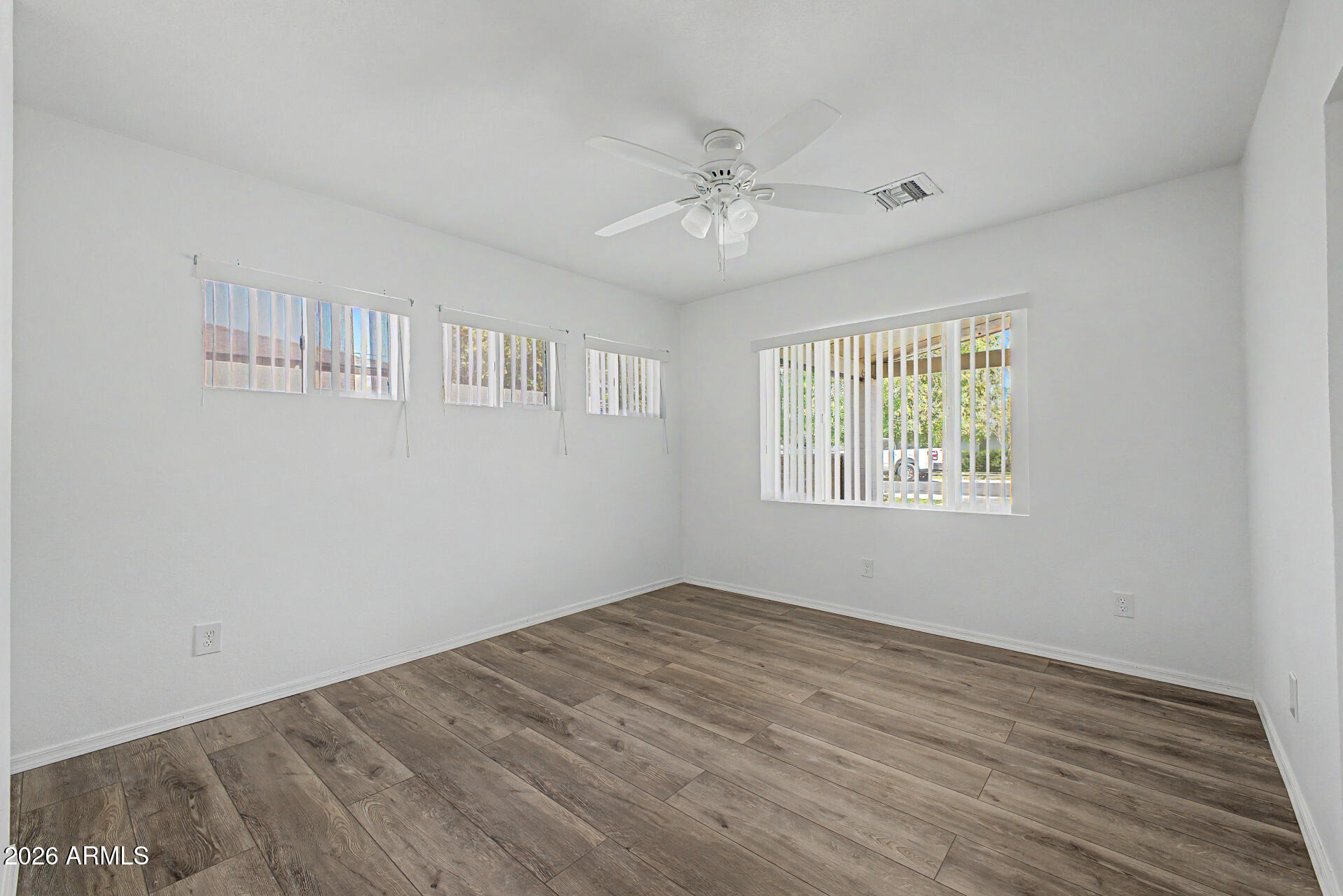 3907 East Mulberry Drive Phoenix, AZ 85018 - Photo 13 of 48 a view of an empty room with wooden floor and a window