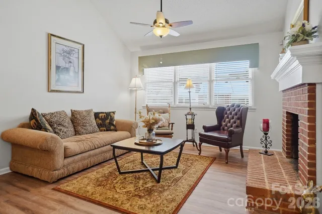 a view of a hallway with wooden floor and a bathroom