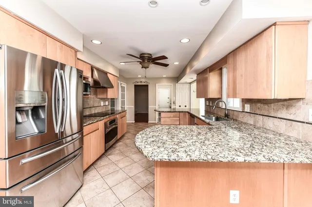 a kitchen with stainless steel appliances granite countertop a refrigerator and a stove