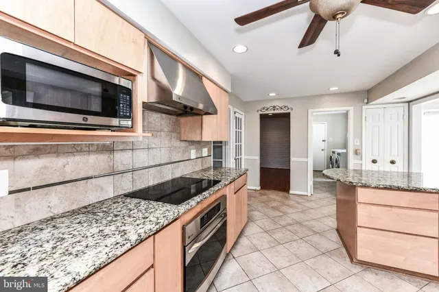 a kitchen with stainless steel appliances granite countertop a sink and a stove