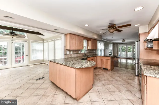 a large kitchen with kitchen island granite countertop a large counter top and stainless steel appliances