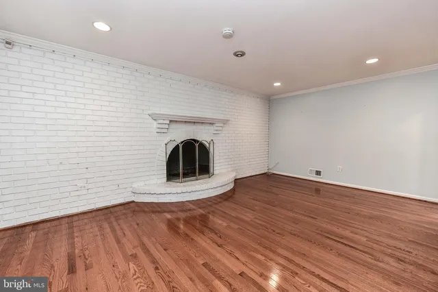 a view of a room with wooden floor and a ceiling fan