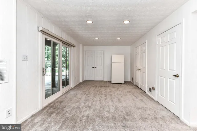 an empty room with windows and closet