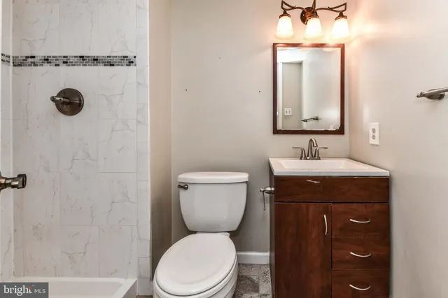 a bathroom with a toilet a sink and mirror