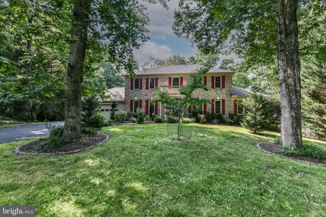 a front view of a house with a yard and trees