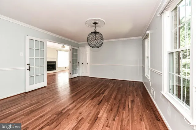 a view of a hallway with wooden floor and a window