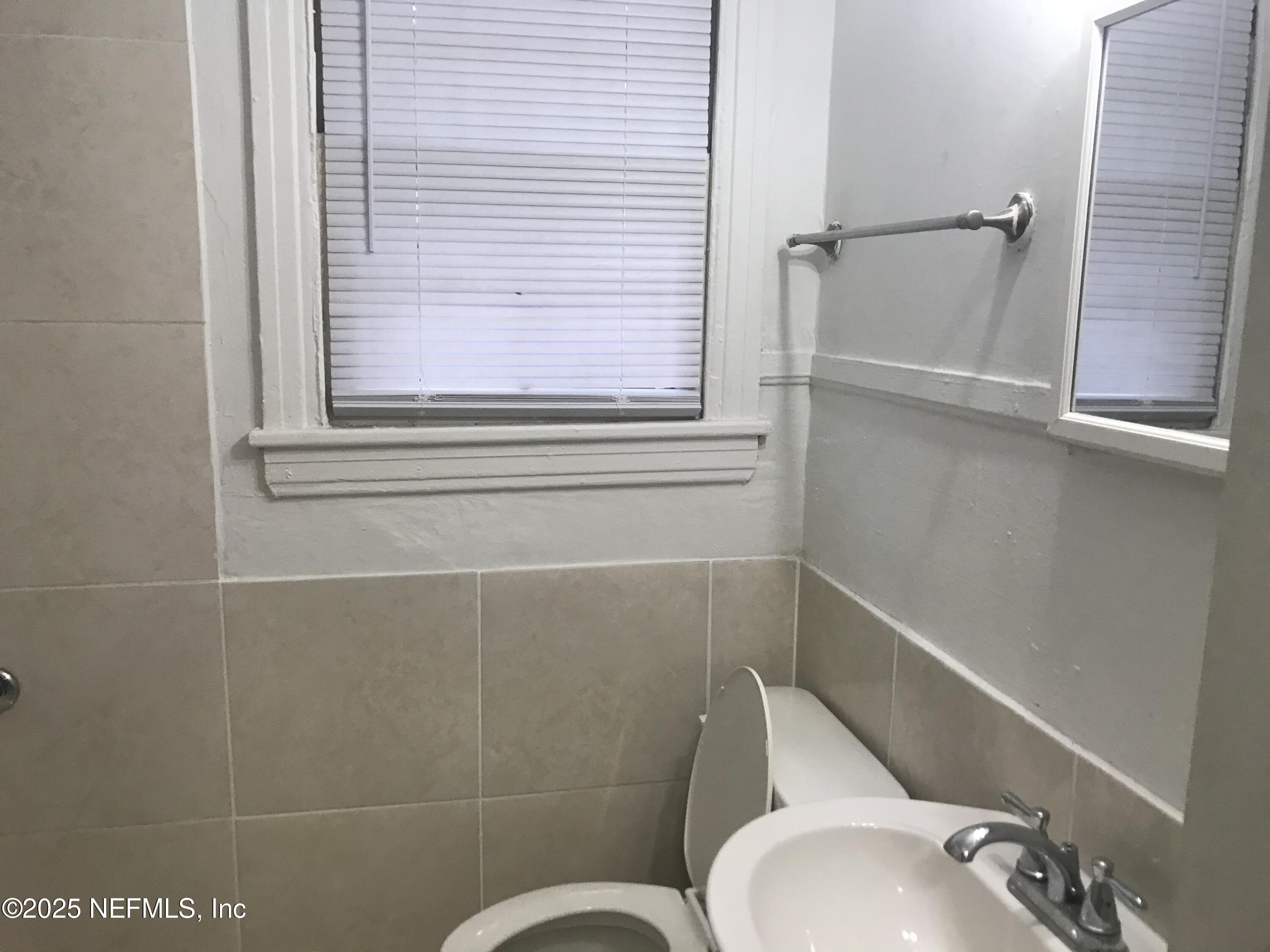 1322 Steele Street Jacksonville, FL 32209 - Photo 13 of 14 a bathroom with a toilet sink and mirror