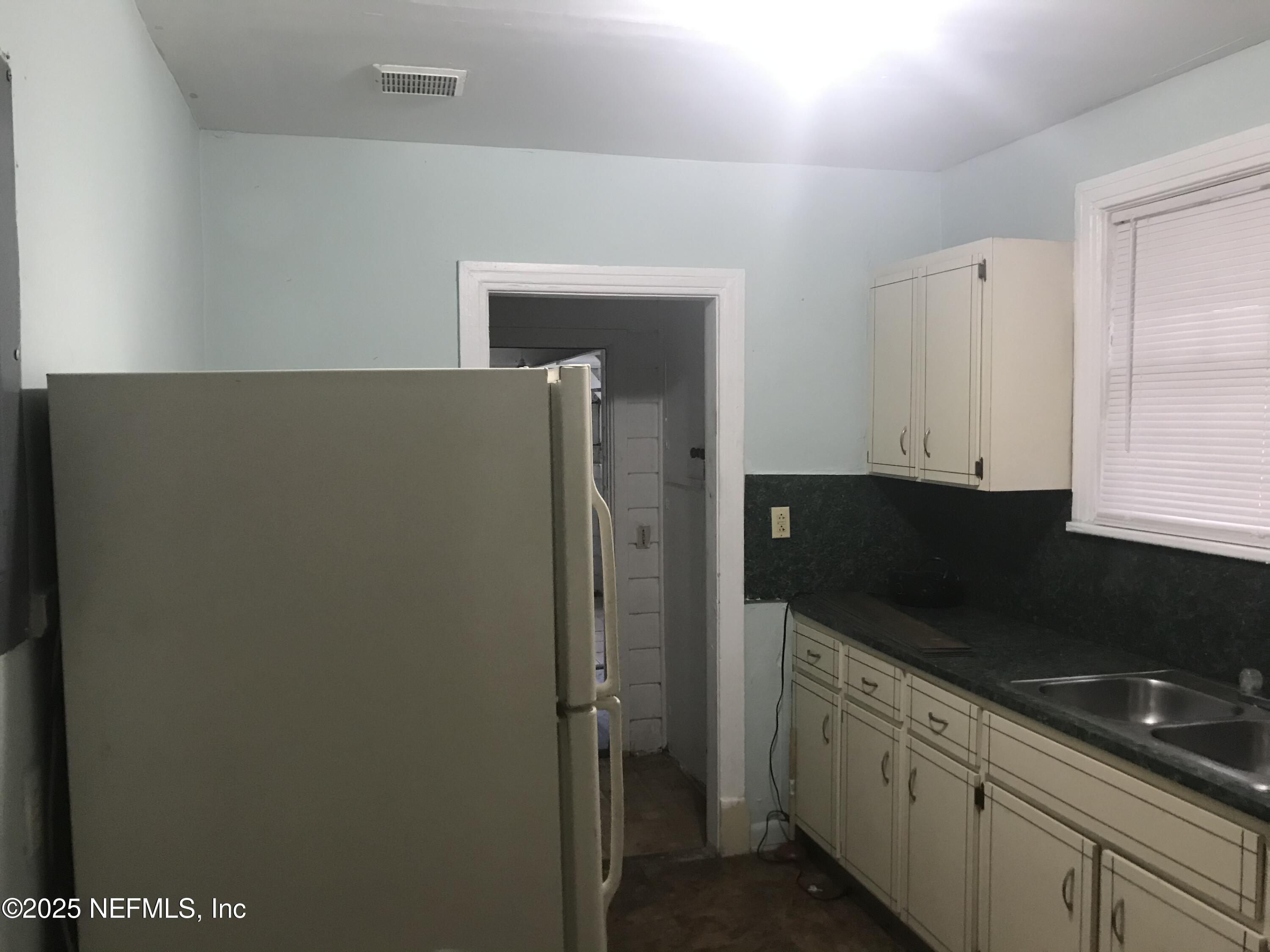 1322 Steele Street Jacksonville, FL 32209 - Photo 7 of 14 a kitchen with a refrigerator and cabinets