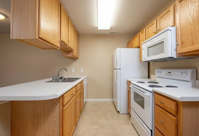a kitchen with stainless steel appliances granite countertop a sink a stove and refrigerator