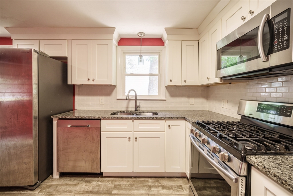 226 Dutchess Street Springfield, MA 01129 - Photo 11 of 39 a kitchen with stainless steel appliances granite countertop a stove a sink and a microwave