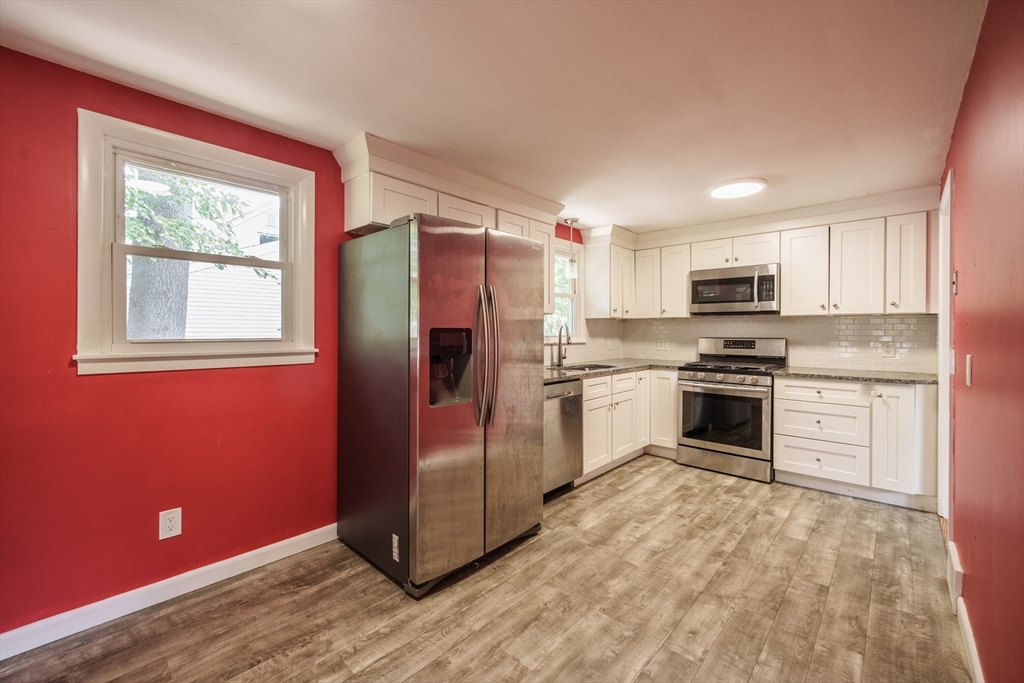 226 Dutchess Street Springfield, MA 01129 - Photo 9 of 39 a kitchen with granite countertop white cabinets and stainless steel appliances
