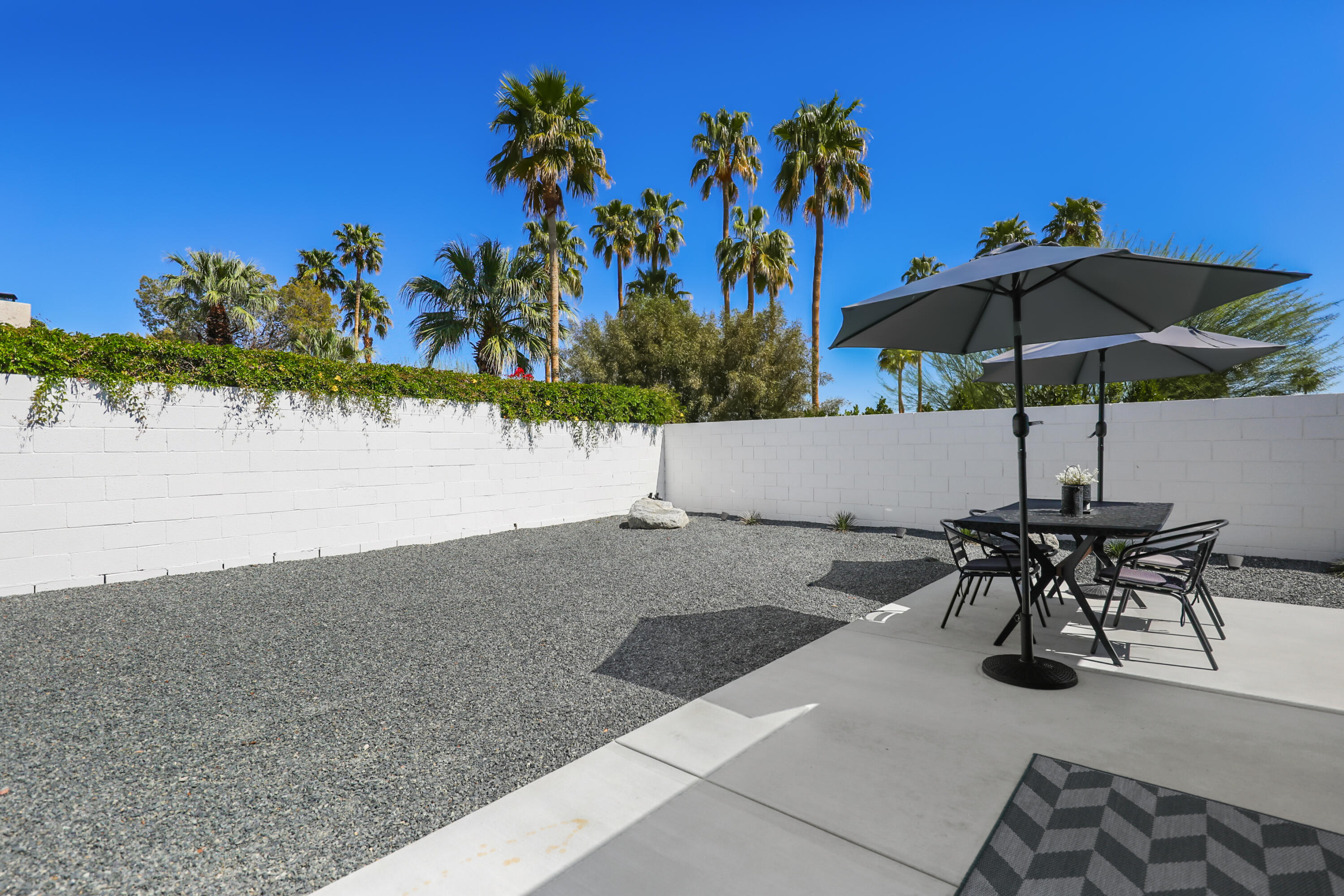 71350 Halgar Road Rancho Mirage, CA 92270 - Photo 27 of 33 a view of a patio with table and chairs under an umbrella