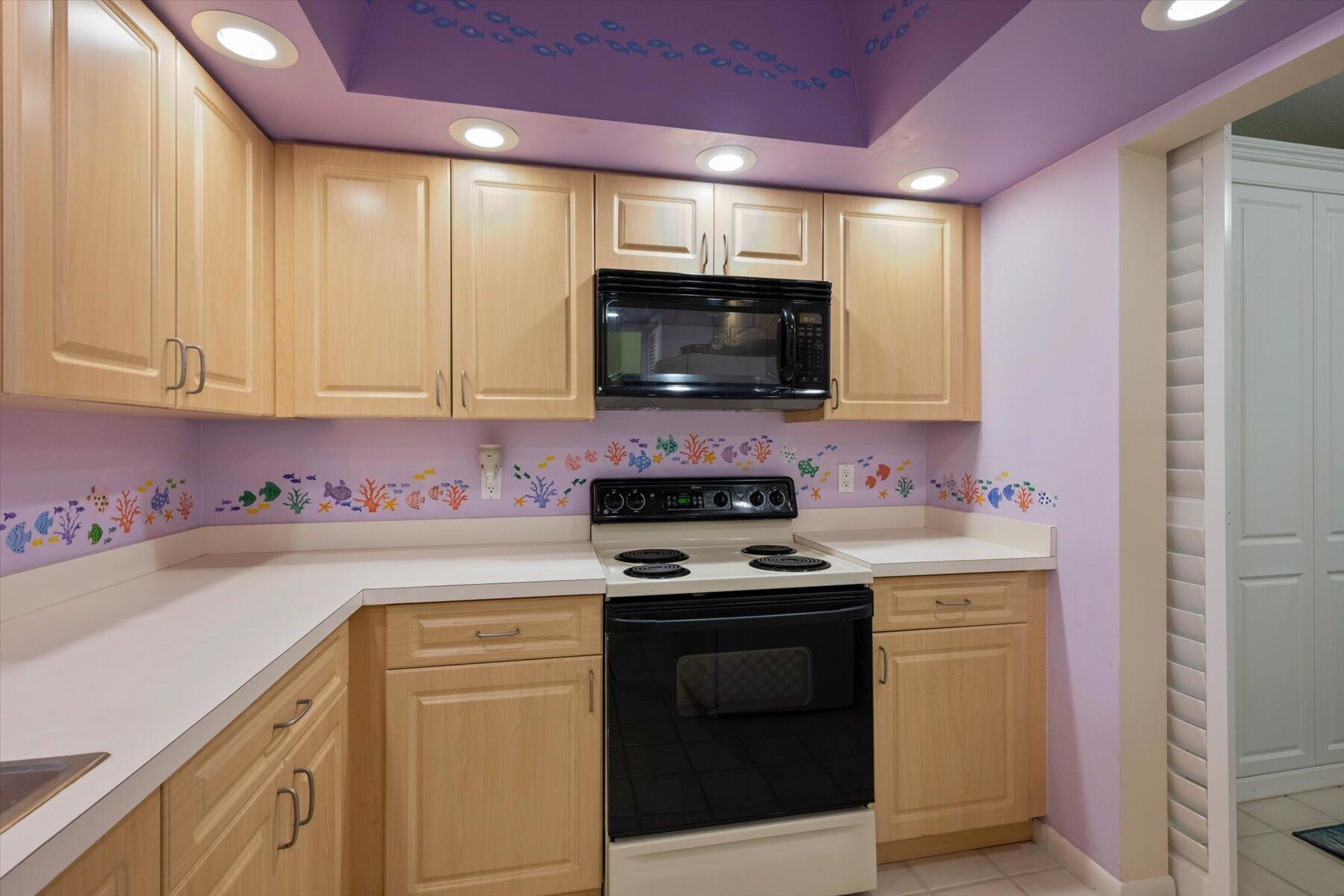 130 Palm Avenue, Unit 20 Jupiter, FL 33477 - Photo 20 of 51 a kitchen with stainless steel appliances granite countertop a stove a sink and a microwave