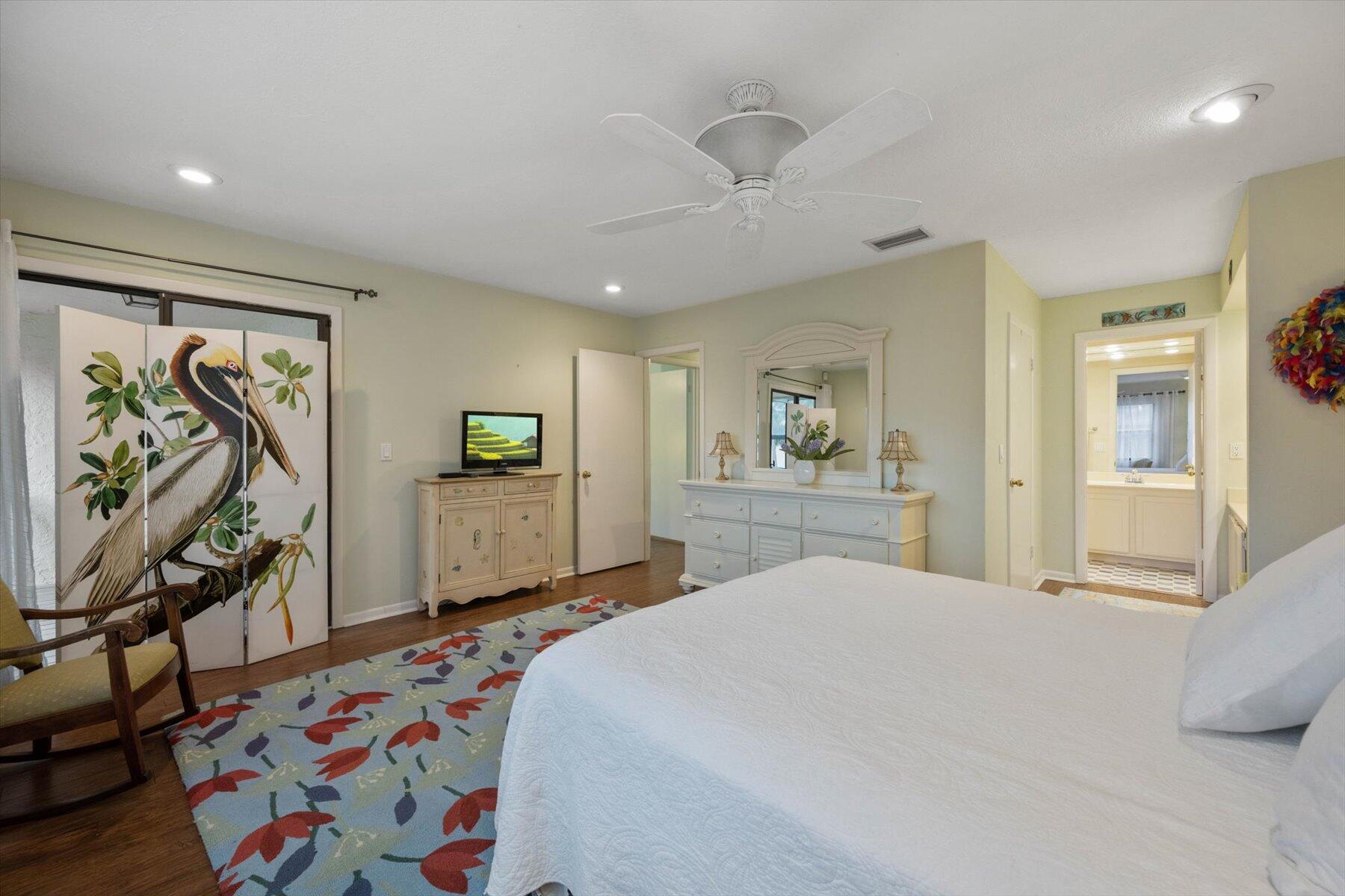 130 Palm Avenue, Unit 20 Jupiter, FL 33477 - Photo 32 of 51 a bedroom with a bed a dresser and painting on the wall