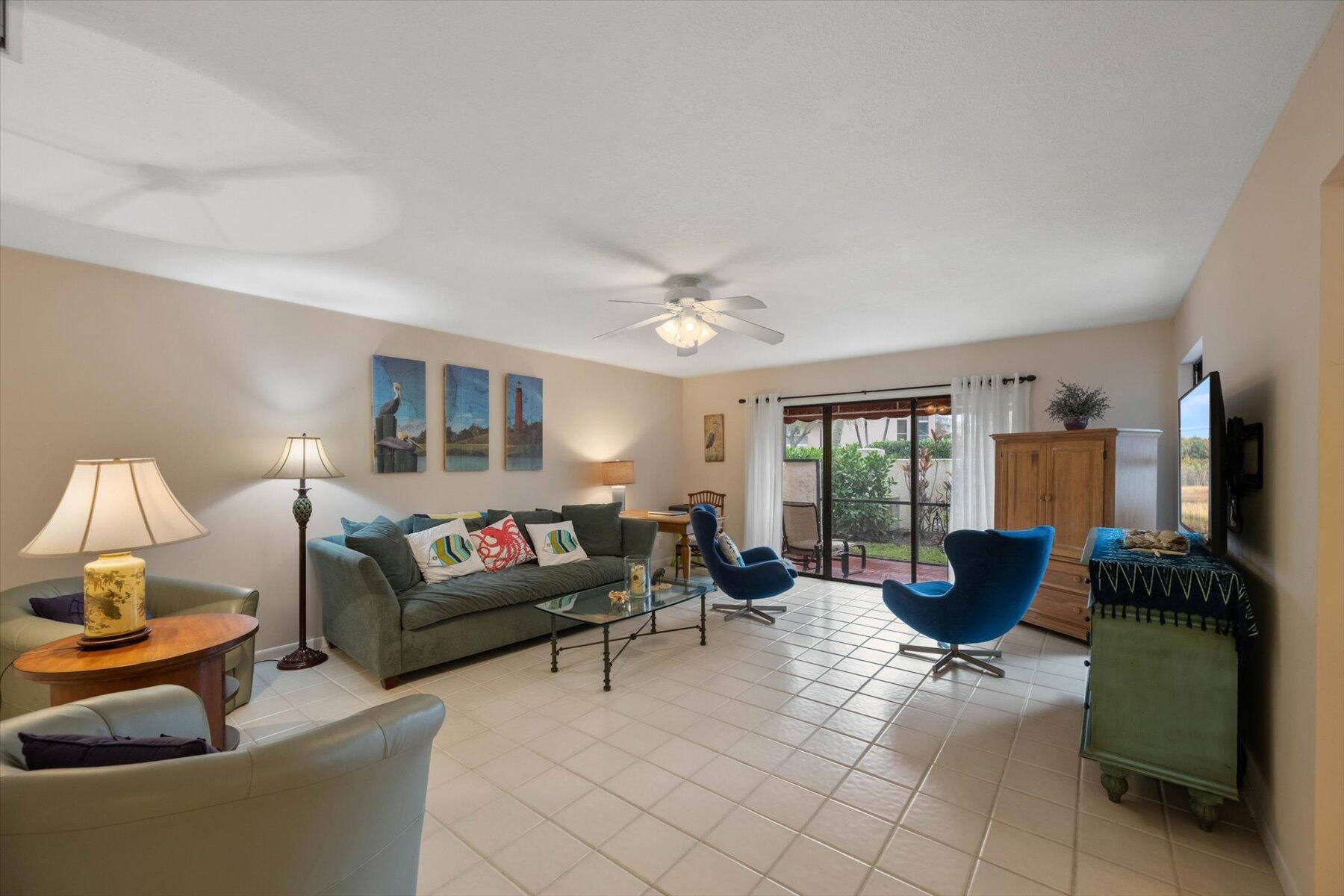 130 Palm Avenue, Unit 20 Jupiter, FL 33477 - Photo 8 of 51 a living room with furniture large window and flat screen tv