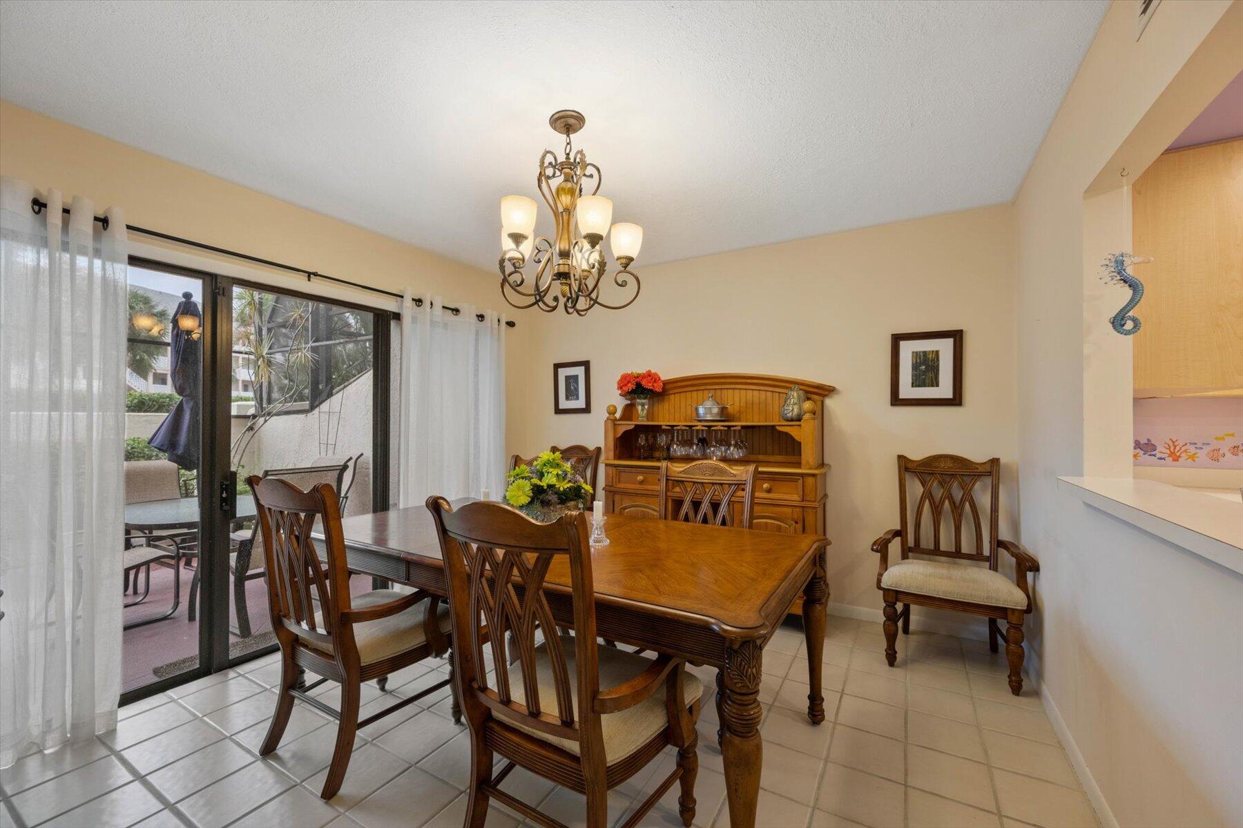 130 Palm Avenue, Unit 20 Jupiter, FL 33477 - Photo 10 of 51 a dining room with furniture a livingroom and chandelier