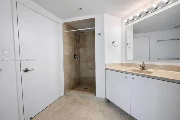 a bathroom with a shower sink and mirror