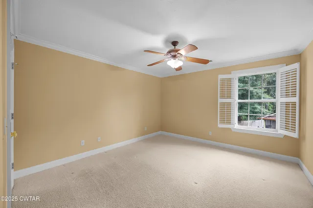 an empty room with a window and a ceiling fan
