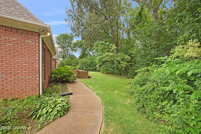 a view of a backyard with potted plants and brick walls