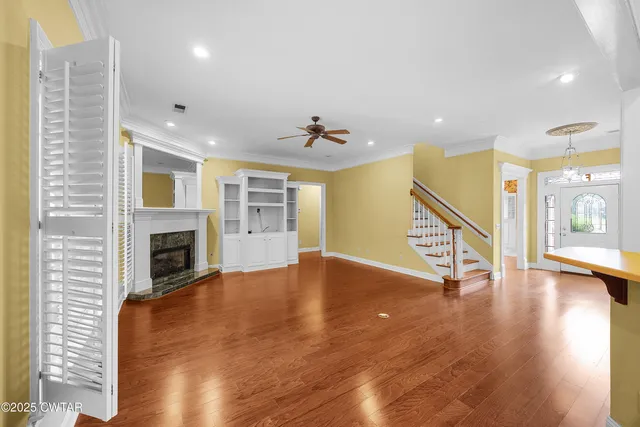 a view of an entryway with wooden floor and a fireplace