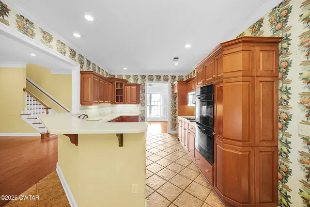 a kitchen with stainless steel appliances a refrigerator and a stove top oven