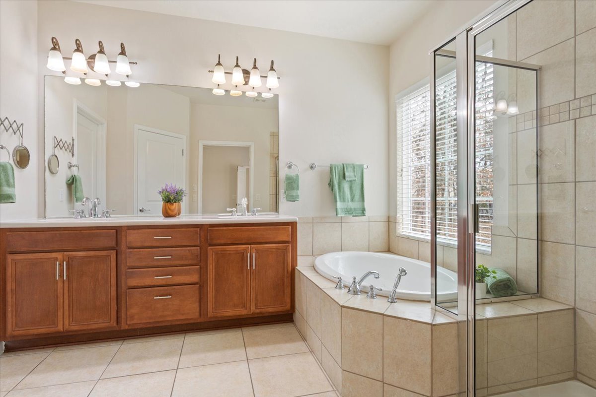 308 Monarch Trail Georgetown, TX 78633 - Photo 25 of 39 The primary bathroom has dual vanities, a bathtub and a separate shower.