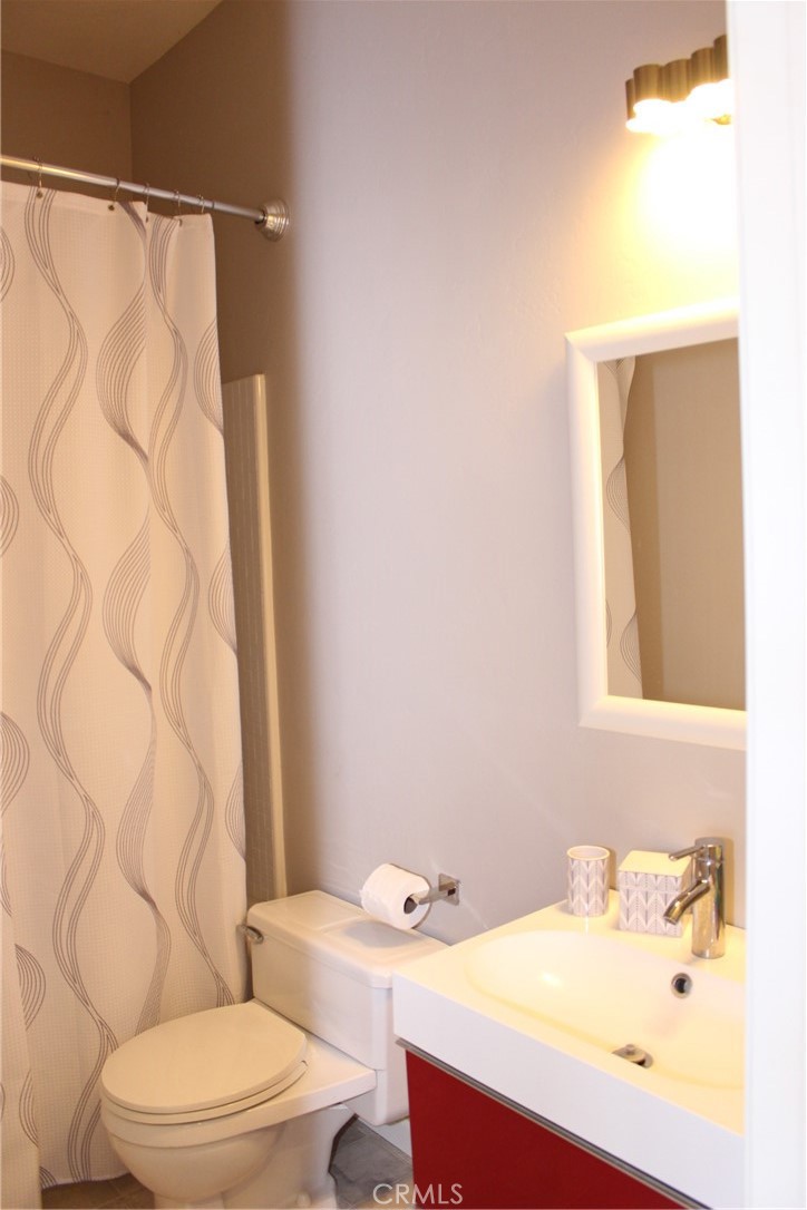 18702 East Ridge View Drive Hidden Valley Lake, CA 95467 - Photo 10 of 18 a bathroom with a sink a toilet and shower curtain