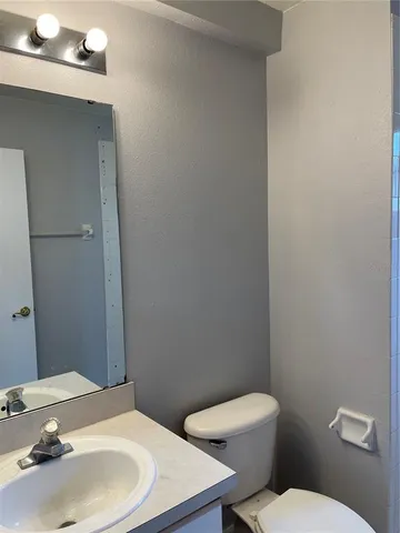 a bathroom with a sink a toilet and mirror