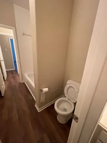 a bathroom with a granite countertop toilet and a sink