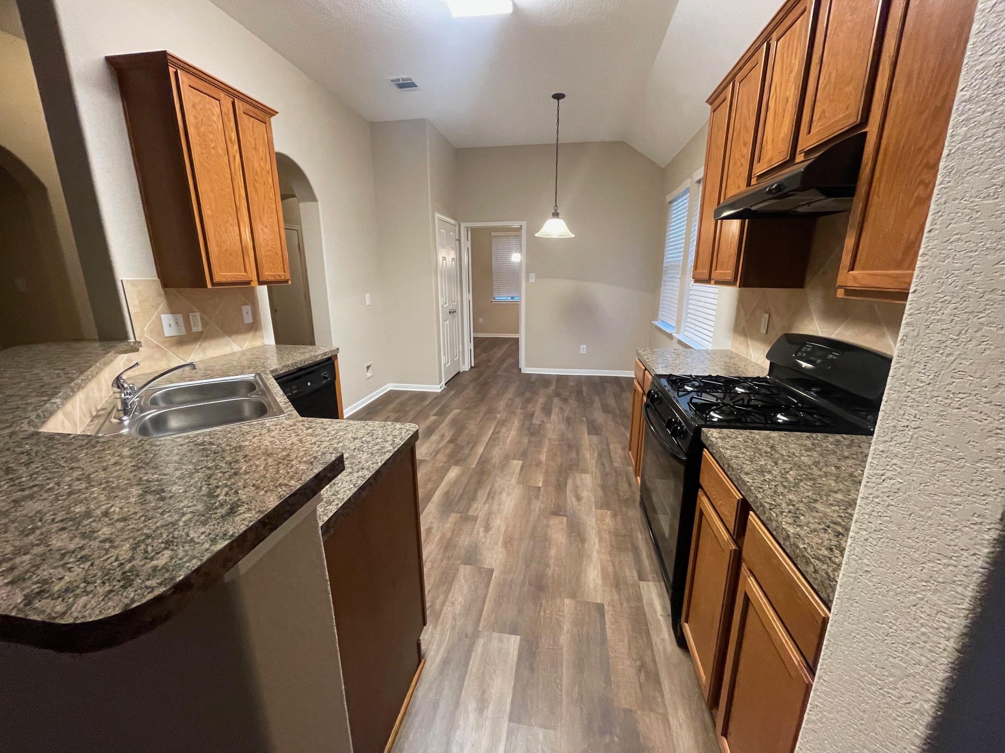 1201 Stallion Ridge Alvin, TX 77511 - Photo 25 of 29 a kitchen with granite countertop a sink a stove and a wooden cabinets