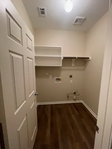 a view of storage and utility room with wooden floor and fan