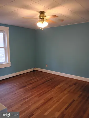 a view of a room with wooden floor and fan