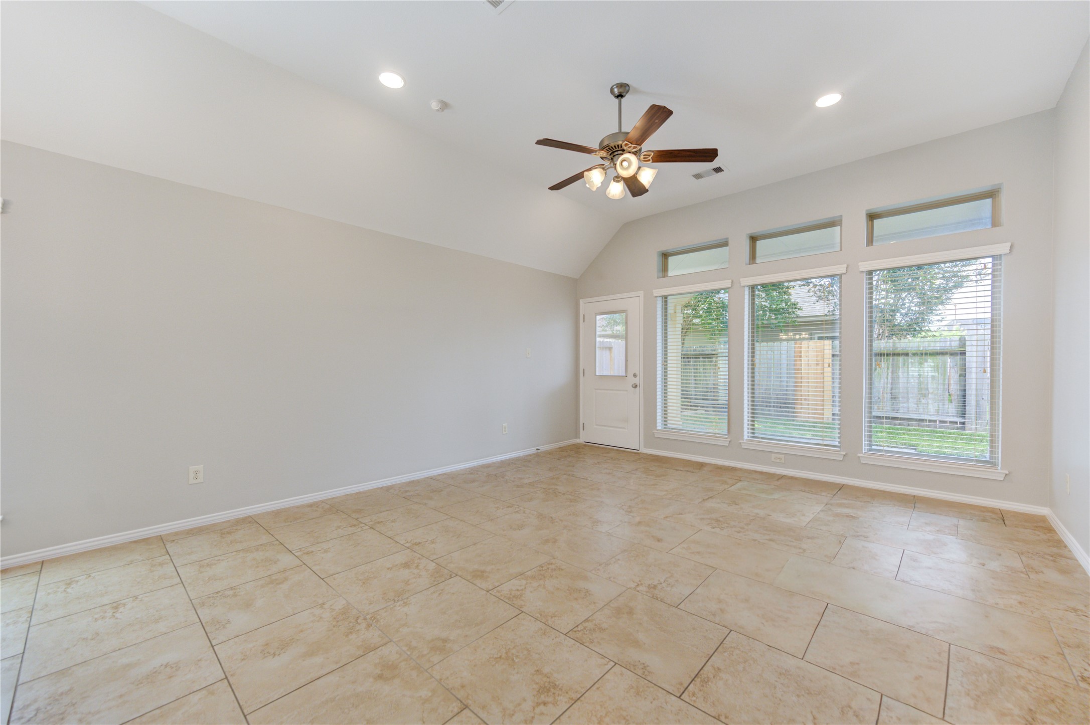 27407 Gatlin Lane Spring, TX 77386 - Photo 18 of 35 Large windows and elevated ceilings fill the living space with light and create a bright, welcoming atmosphere. The open-concept design offers effortless flow to the kitchen and breakfast area while framing peaceful views of the private backyard.