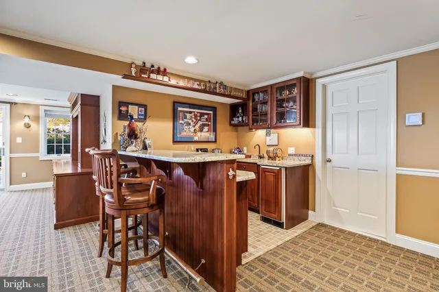 a kitchen with stainless steel appliances granite countertop a refrigerator a sink dishwasher a dining table and chairs with wooden floor