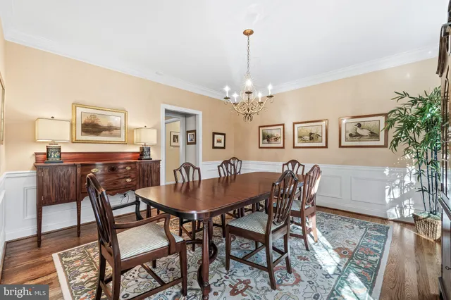 a dining room with furniture a chandelier and wooden floor