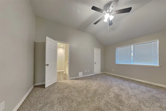 a view of a room with a ceiling fan and a window