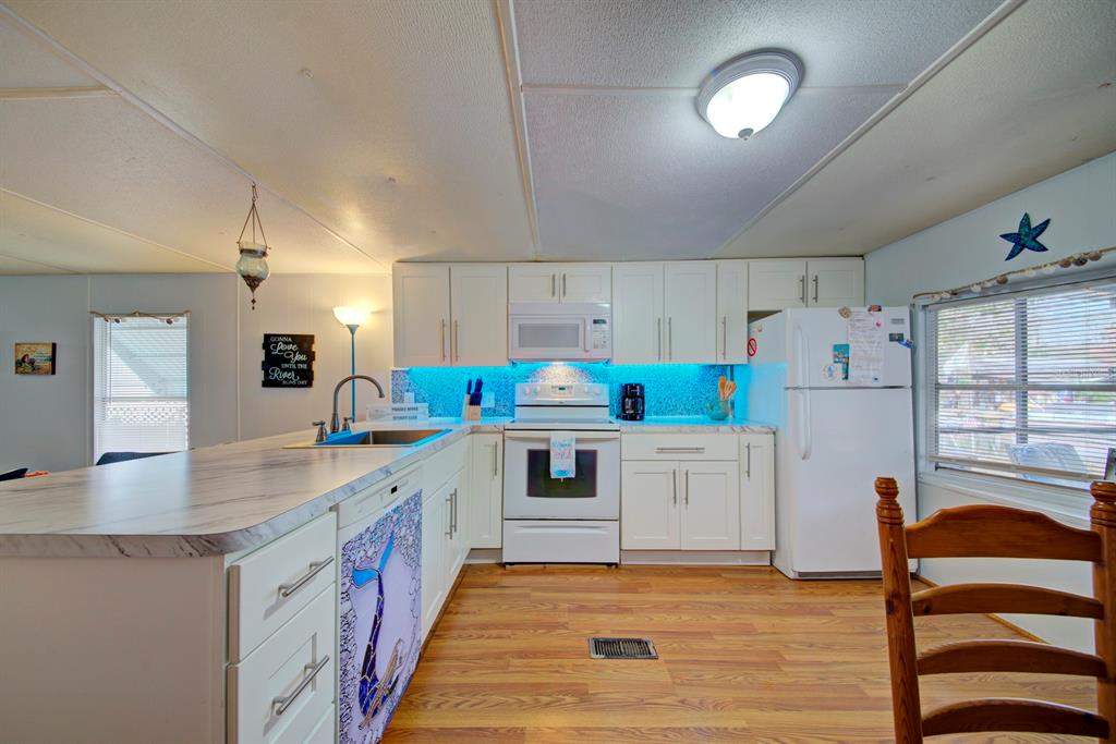 6427 West Richard Drive Weeki Wachee, FL 34607 - Photo 12 of 35 a kitchen with granite countertop white cabinets and white appliances