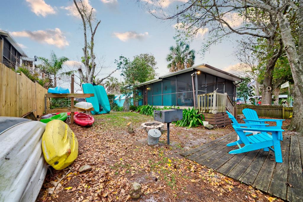 6427 West Richard Drive Weeki Wachee, FL 34607 - Photo 21 of 35 a view of a backyard with table and chairs potted plants and a fire pit