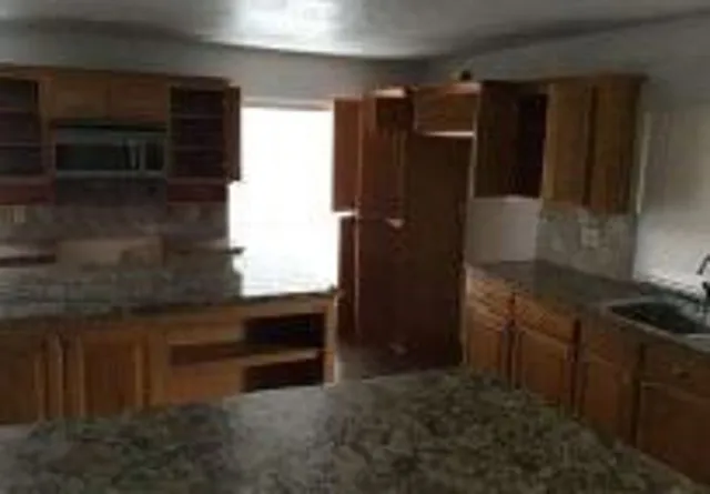 a kitchen with granite countertop a refrigerator and a stove
