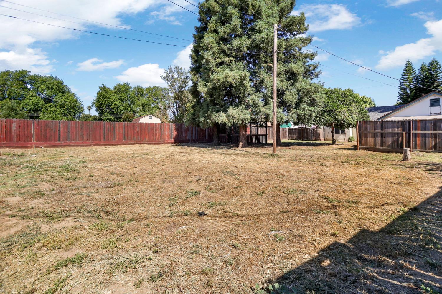 916 Elm Avenue Modesto, CA 95351 - Photo 30 of 52 31. Wide rear yard view Big sky, mature trees, and a generous lot give this property the kind of outdoor potential buyers love to dream about.