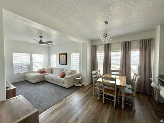 327 West Main Street, Unit 14 Santaquin, UT 84655 - Photo 5 of 20 Living room with dark wood-style flooring, a textured ceiling, a ceiling fan, a chandelier, and healthy amount of natural light