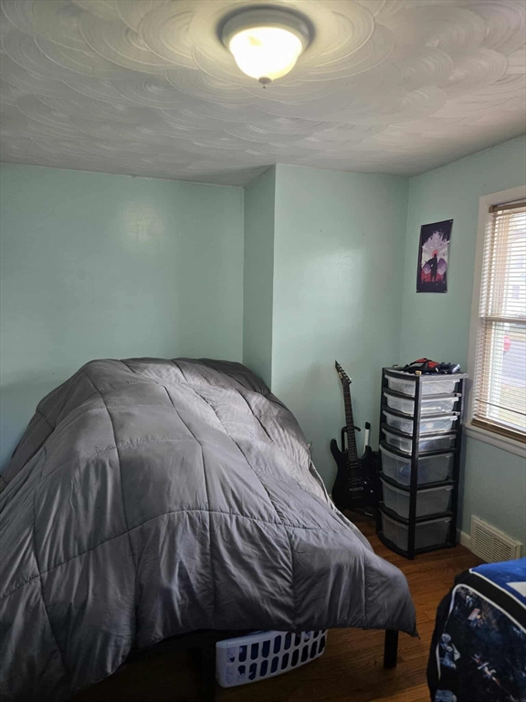 78 San Miguel Street Springfield, MA 01104 - Photo 11 of 26 a bedroom with a bed and a chandelier