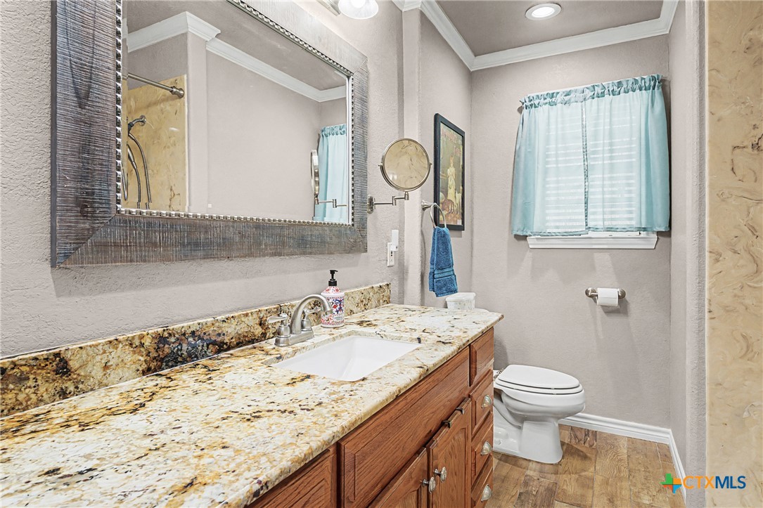 1601 Sunset Circle Cameron, TX 76520 - Photo 24 of 40 a bathroom with a granite countertop sink a toilet and a mirror