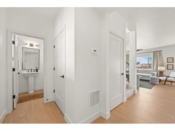 a view of a livingroom with wooden floor and furniture