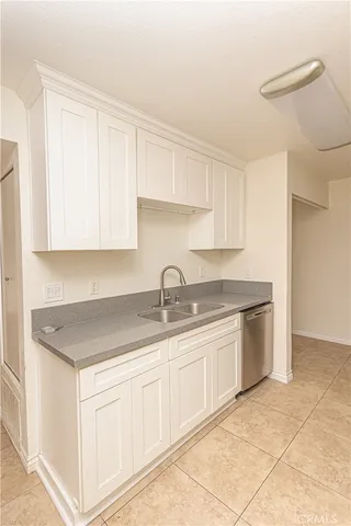 a kitchen with white cabinets appliances and sink