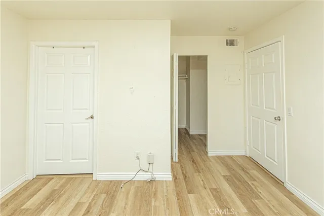 a view of a room with wooden floor and a bathroom