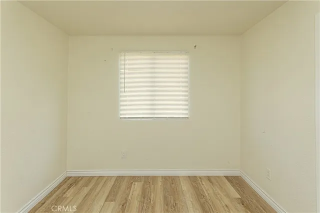 a view of a room with wooden floor and small window