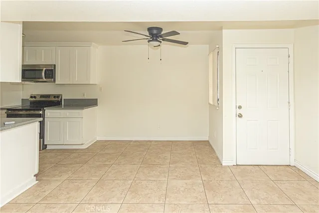 a view of a kitchen with white cabinets and a stove top oven