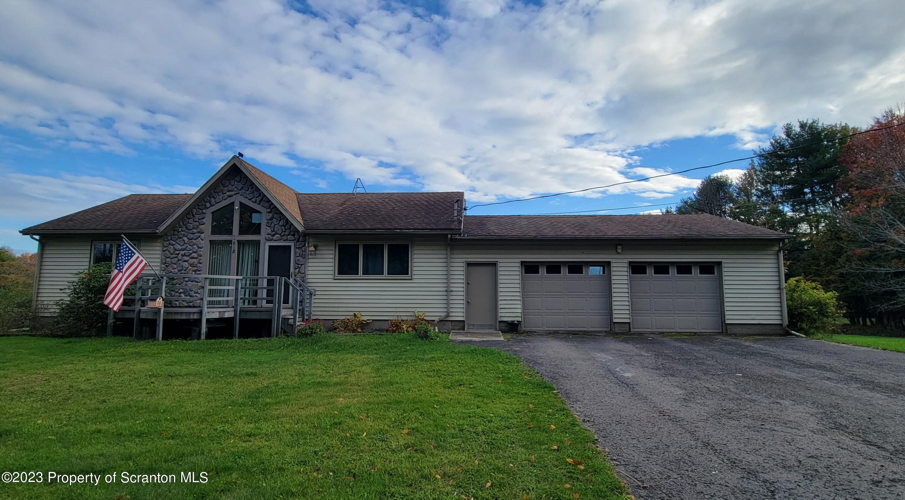 618 Kennedy Road Brackney, PA 18812 - Photo 1 of 35 a front view of a house with a garden and deck